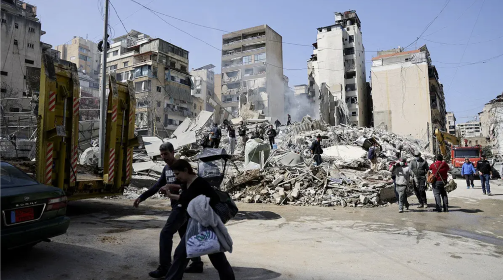 Several people walk among the rubble at the site of an Israeli attack, following the escalation of tensions between Hezbollah and Israel amid the US-Israeli conflict with Iran, in the Zuqaq al-Blat neighborhood of central Beirut, Lebanon - REUTERS/KHALIL ASHAWI