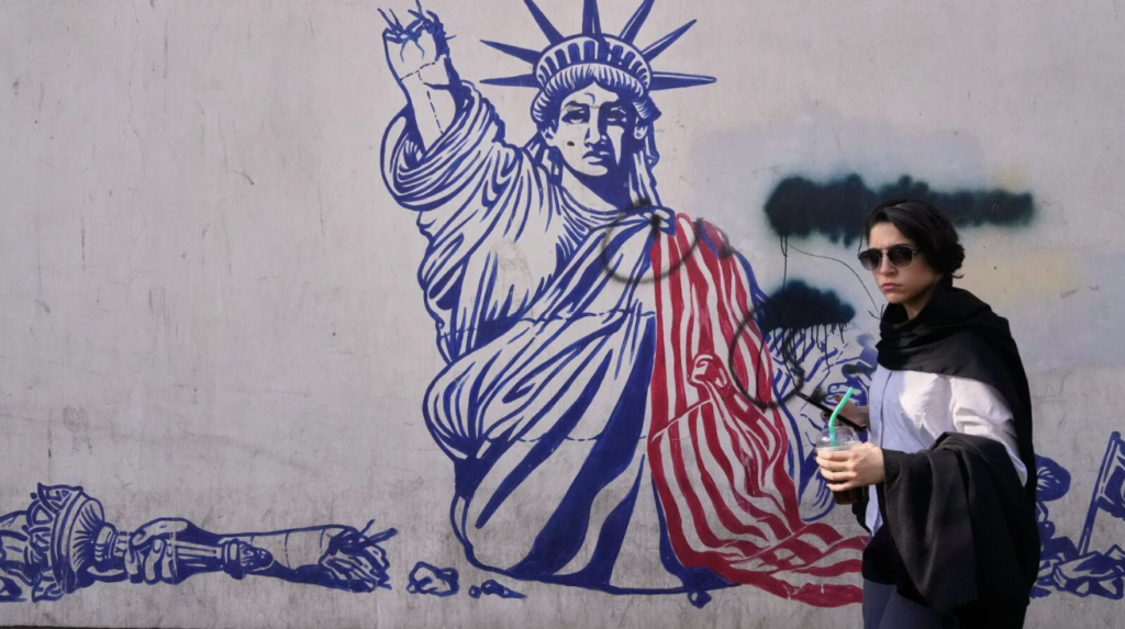 A woman walks past an anti-American mural on the wall of the former U.S. embassy, ​​now a museum, in Tehran. AP Photo/Vahid Salemi